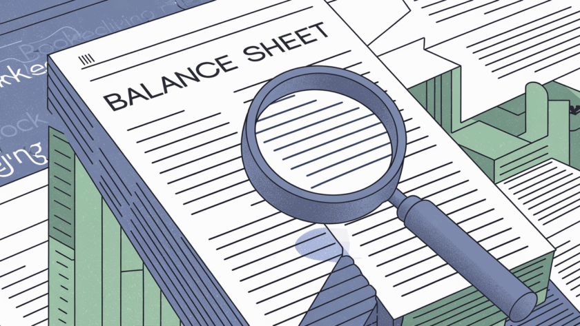 A magnifying glass examining a balance sheet.
